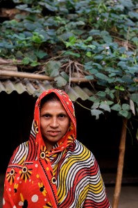 A woman stands outside her house in Korail slum in Dhaka